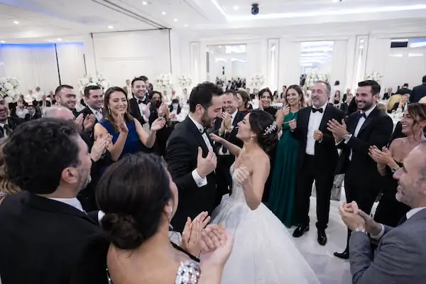 Düğün kutlamasında dans eden çift ve alkışlayan misafirler